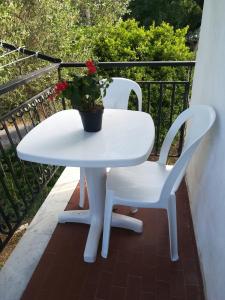 una mesa blanca y sillas en un balcón con una maceta en Appartamento Sole e Mare, en Palinuro