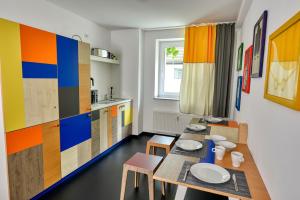 a kitchen with a table and chairs and colorful cabinets at Hostel am Niederfeldsee in Essen