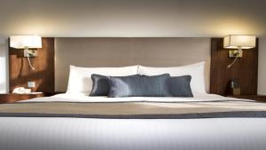 a bedroom with a large bed with two lamps at Copthorne Downtown by Millennium in Abu Dhabi