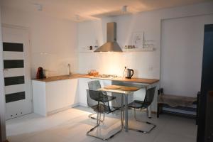a kitchen with a table and some chairs in it at Apartament Centrum Warszawy in Warsaw