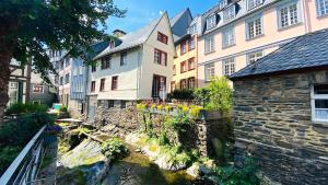 eine Gruppe von Gebäuden und ein Fluss in einer Stadt in der Unterkunft Monschau-Auszeit: Historisch wohnen direkt am Bach in Monschau