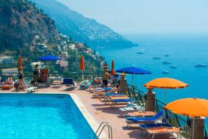 una piscina con sillas y sombrillas junto al océano en Casa Giostrello, en Positano