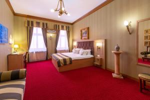 une chambre d'hôtel avec un lit et un tapis rouge dans l'établissement Hotel Am Ring, à Sibiu