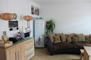 ein Wohnzimmer mit einem Sofa und einem Kühlschrank in der Unterkunft Hotel zur Post Schwanheim in Frankfurt am Main