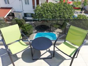 een paar stoelen en een tafel op een balkon bij Stars Palace in Jezera