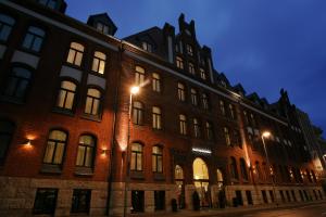 a large brick building on a street at night at Grand Palace Hotel Hannover in Hannover