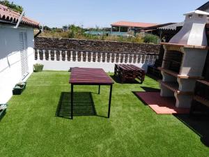 a lawn with a table in the middle of a yard at O Mercadinho in Poiares