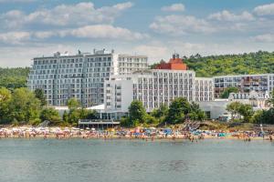 a group of people on a beach with buildings at Apartamenty Sun & Snow Balticus in Międzyzdroje