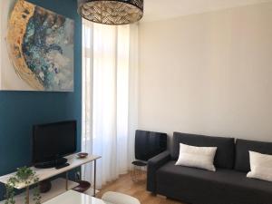 a living room with a couch and a tv at Un petit coin de Bastide in Carcassonne