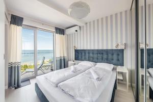 a bedroom with a bed with a view of the ocean at Apartamenty Sun & Snow Balticus in Międzyzdroje
