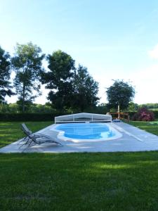 a swimming pool in the middle of a grass field at Les Baillis in Villegenon