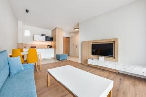 - un salon avec un canapé bleu et une table dans l'établissement Apartamenty Sun & Snow Bel Mare, à Międzyzdroje