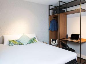 a bedroom with a bed and a laptop on a desk at ibis Brussels Centre Chatelain in Brussels