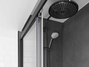a shower with a shower head in a bathroom at ibis Brussels Centre Chatelain in Brussels