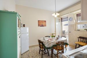 a kitchen and dining room with a table and chairs at Tra il Centro e il Mare Apartment con terrazzo in Aci Castello