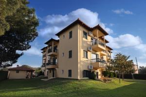 a large apartment building with a green yard at Maistrali Apartments in Ormos Panagias