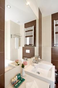 uma casa de banho com um lavatório e um espelho em Grand Palace Hotel Hannover em Hanôver