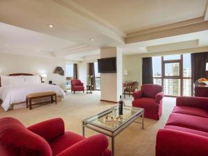 ein Hotelzimmer mit einem Bett und roten Stühlen in der Unterkunft Swissotel Lima in Lima