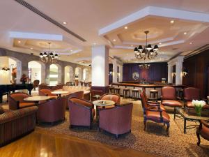 una hall dell'hotel con tavoli, sedie e un bar di Swissotel Lima a Lima
