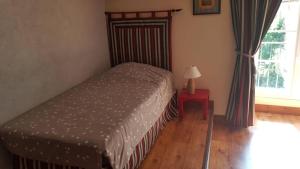 sypialnia z łóżkiem, lampką i oknem w obiekcie La Truffiere w mieście Champigny-sur-Veude