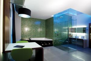 a bathroom with a tub, a toilet and a sink at Mood - Private Suites in Montijo