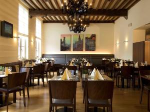 een eetkamer met tafels en stoelen en een kroonluchter bij Hotel Ibis Brugge Centrum in Brugge