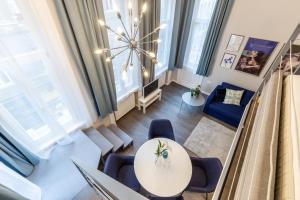 Una sala de estar con una mesa y sillas azules. en W33 - Prime Location - Comfortable Quality Apartments by BQA, en Budapest