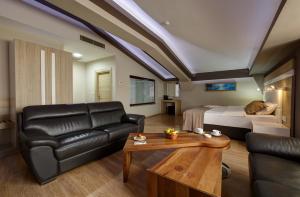 Sala de estar con sofá, cama y mesa en Arus Hotel, en Eskisehir