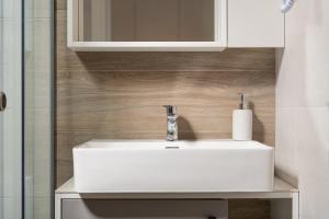 een badkamer met een witte wastafel en een spiegel bij Sky Luxury Suites in Sarti +44 foto's