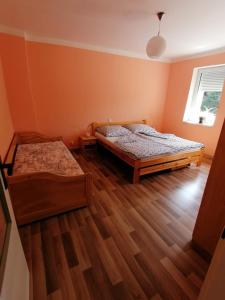 two beds in a room with wooden floors at Apartment U Panorámy in Jáchymov