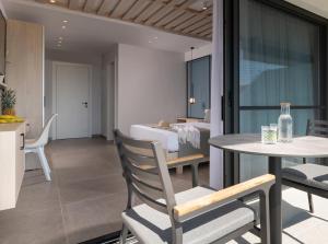 een kamer met een bed, een tafel en stoelen bij Sky Luxury Suites in Sarti