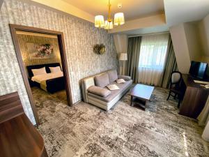 un soggiorno con divano, letto e specchio di Hotel Arnia a Iaşi