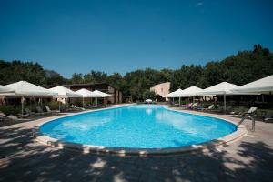 a large swimming pool with white umbrellas and chairs at Forrest Park&Resort in Orlovshchina