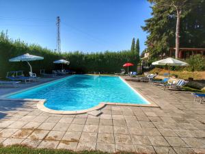 ein großer Pool mit Stühlen und Sonnenschirmen in der Unterkunft Belvilla by OYO I Molinari in Gualdo Cattaneo