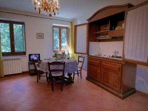 eine Küche und ein Esszimmer mit einem Tisch und Stühlen in der Unterkunft Belvilla by OYO I Molinari in Gualdo Cattaneo