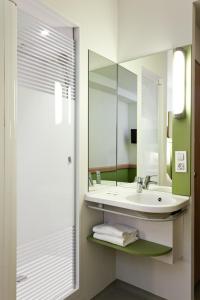 a bathroom with a sink and a mirror at ibis budget Antwerpen Port in Antwerp