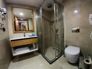 a bathroom with a shower and a toilet and a sink at Sundia By Liberty Oludeniz in Oludeniz