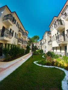 a row of apartment buildings with a grass yard at Sundia By Liberty Oludeniz in Oludeniz