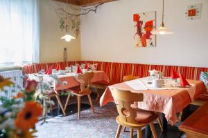 un ristorante con tavoli e sedie con tovaglioli rossi di Hotel Garni Brigitte a Bürserberg