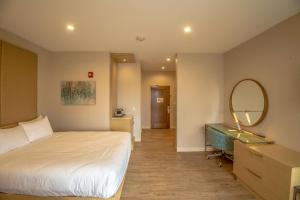 a bedroom with a bed and a mirror and a desk at The Chandler at White Mountains, Ascend Hotel Collection in Bethlehem