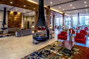 a lobby with a fireplace and red chairs at The Chandler at White Mountains, Ascend Hotel Collection in Bethlehem
