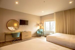 a hotel room with a bed and a desk and a mirror at The Chandler at White Mountains, Ascend Hotel Collection in Bethlehem