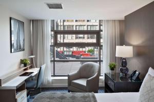 a hotel room with a bed and a desk and a window at The Historic Blue Angel Hotel Lexington Ave, an Ascend Collection in New York