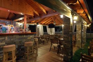 a restaurant with a bar and tables and chairs at Maistrali Apartments in Ormos Panagias