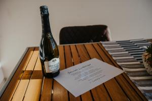 - une bouteille de vin assise sur une table avec un morceau de papier dans l'établissement Laukbalozu camping, à Jūrkalne