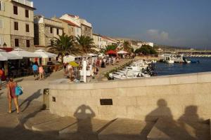 a group of people walking around a harbor with boats at APARTMENT ELI in Pag