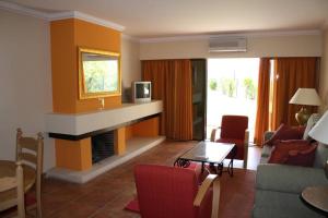 a living room with a fireplace and a couch and a table at Apartamento T1 - Praia Senhora da Rocha in Porches