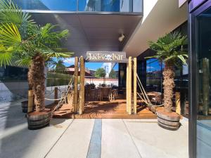 una entrada al hotel con palmeras y un columpio en ibis Styles Liege Guillemins, en Lieja