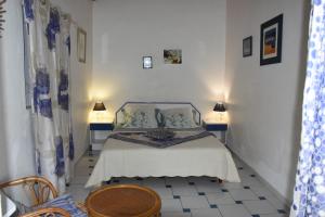 - une chambre avec un lit, deux tables et deux lampes dans l'établissement La Bougainvillée, à Saint-François 50 autres photos