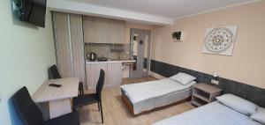 a small room with a kitchen and a bed and a table at Dom Wypoczynkowy Oliwka in Ustka